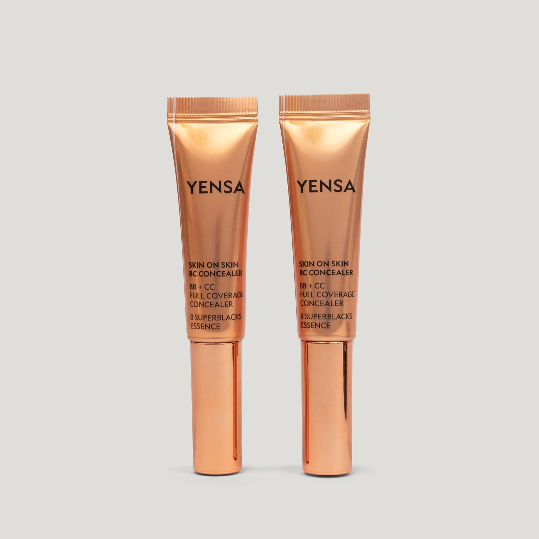 Skin On Skin BB + CC Concealer in two gold tubes displayed on a light background, showcasing full coverage serum formula.