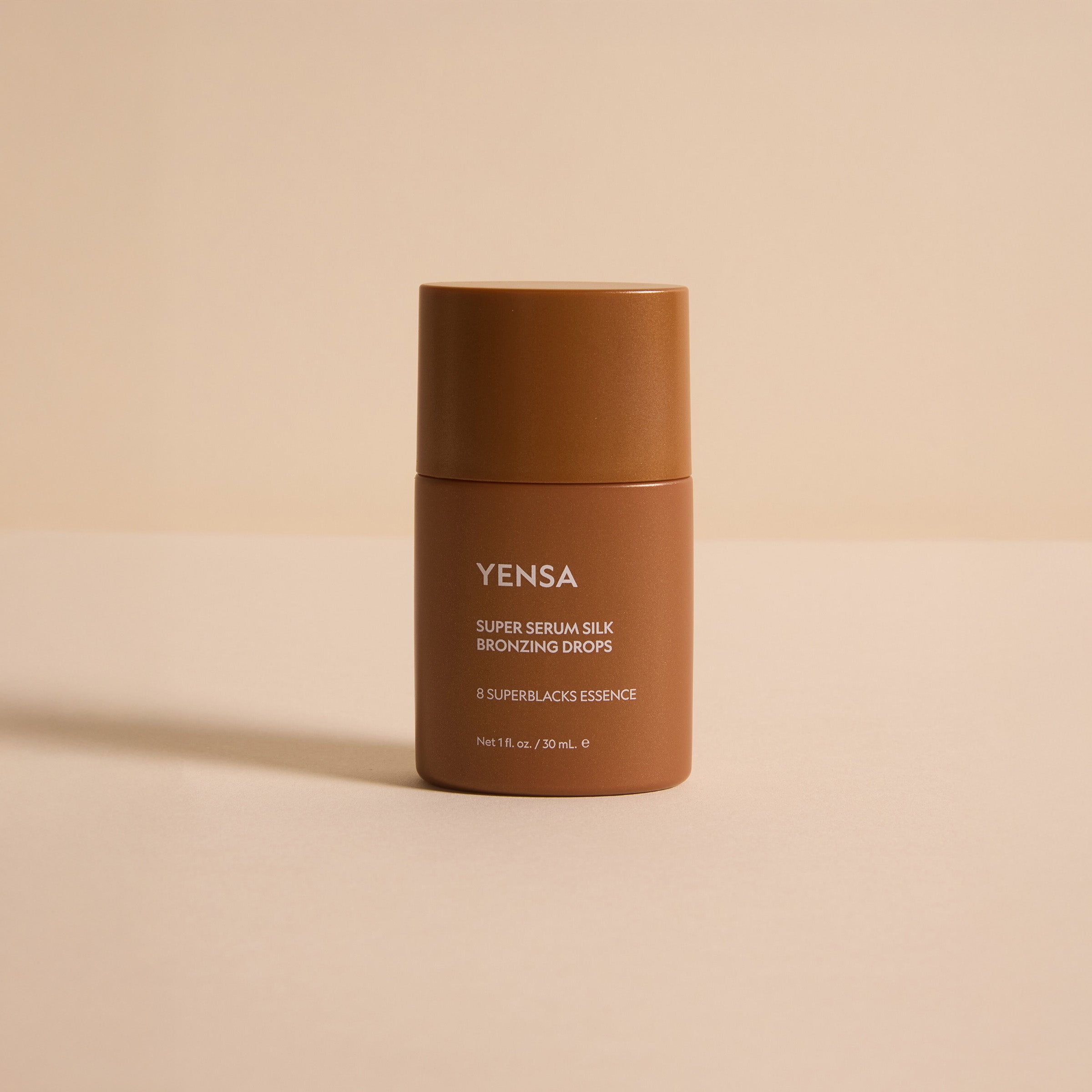 Super Serum Silk Bronzing Drops bottle on a neutral background showcasing its radiant glow properties.
