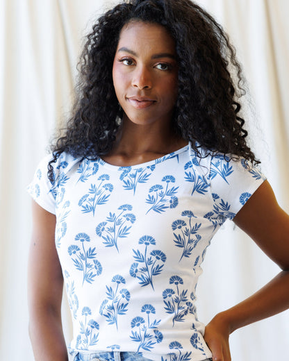 Artistic Tee premium graphic t-shirt with floral design modeled by a woman with curly hair.