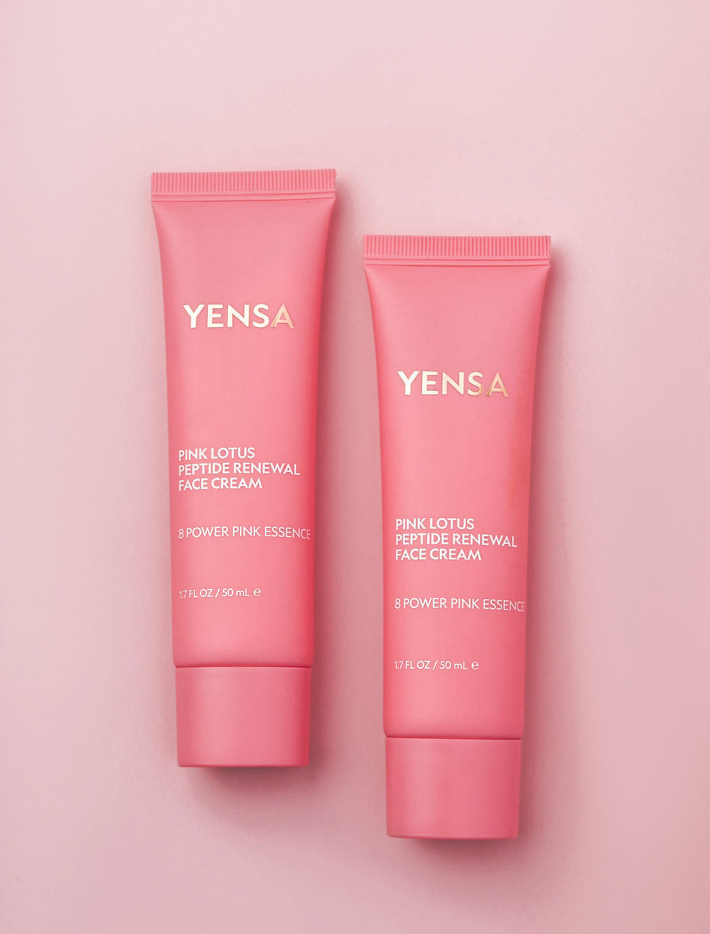 Pink Lotus Peptide Renewal Face Cream tubes on a pink background, offering hydration and skincare benefits.