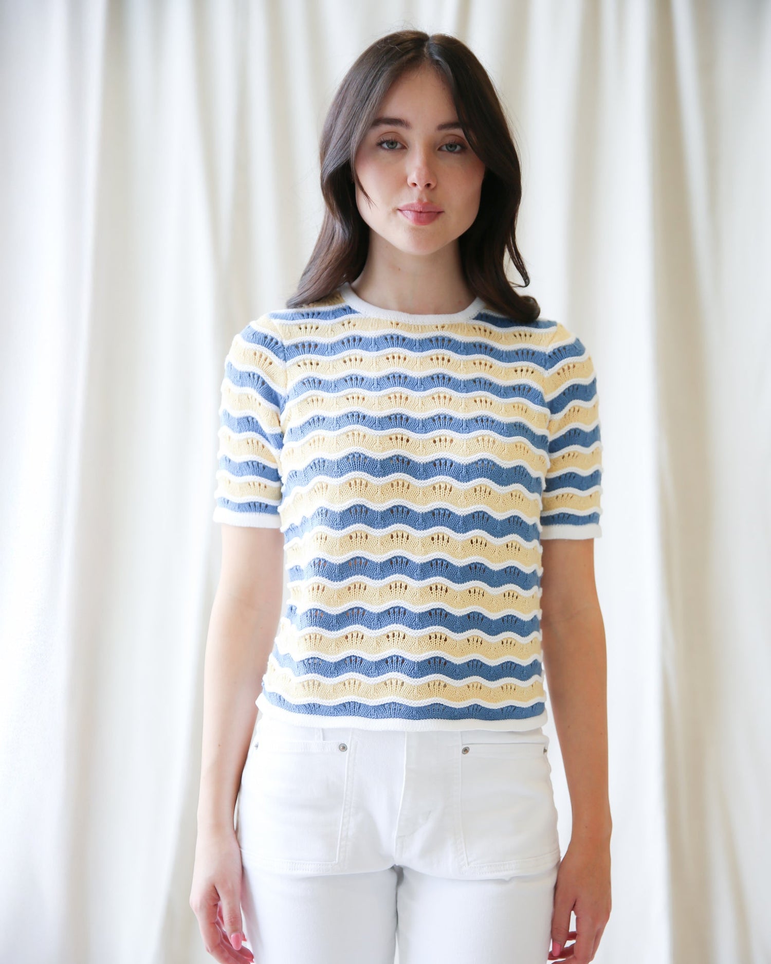 Model wearing High Tides Sweater with blue, white, and yellow stripes, showcasing its cozy knit design.