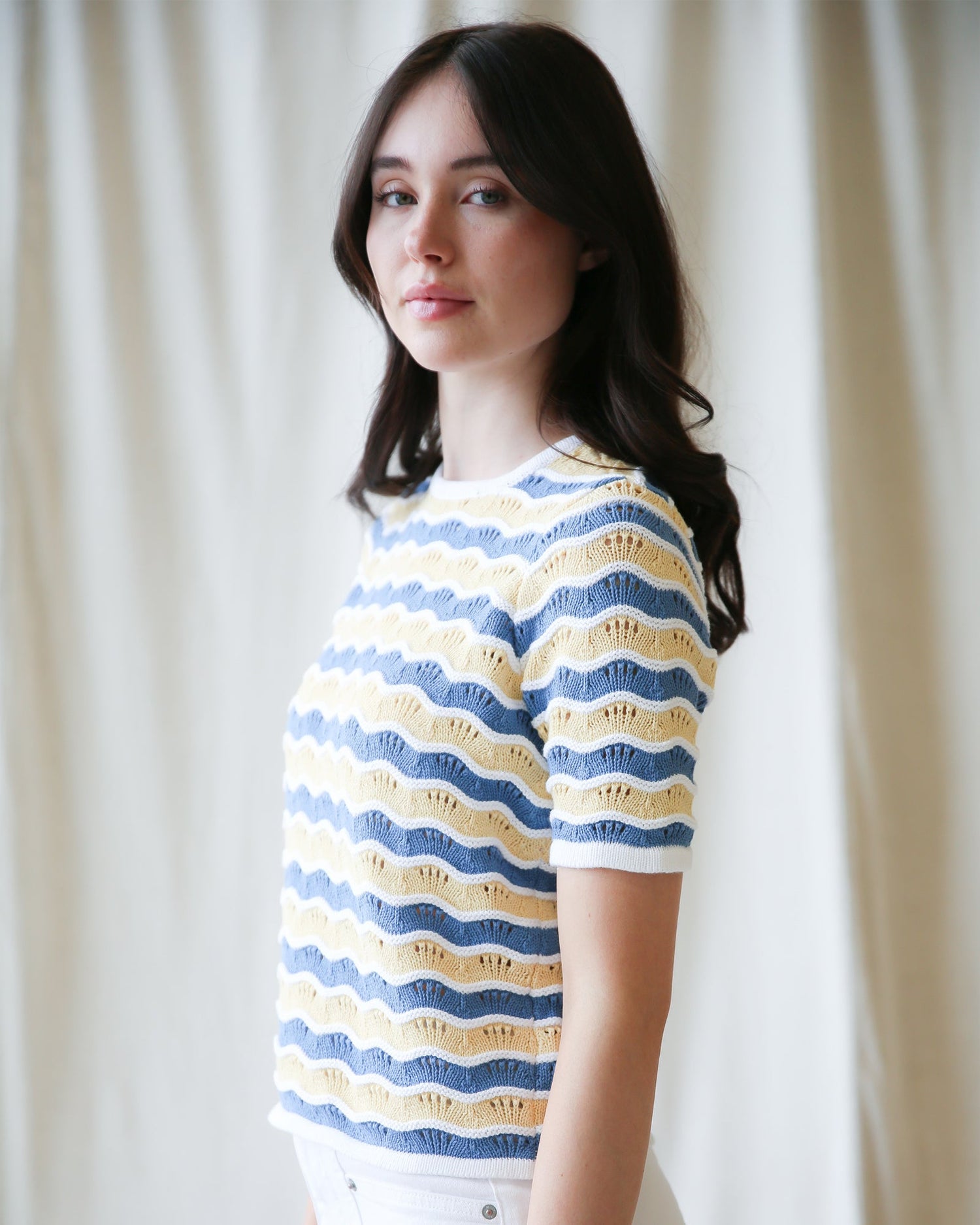 High Tides Sweater cozy knit pullover displayed on a model, featuring blue and yellow striped design.