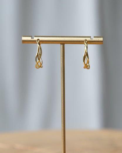 Braided Hoop Earrings elegantly displayed on a stand, showcasing their unique braided design.