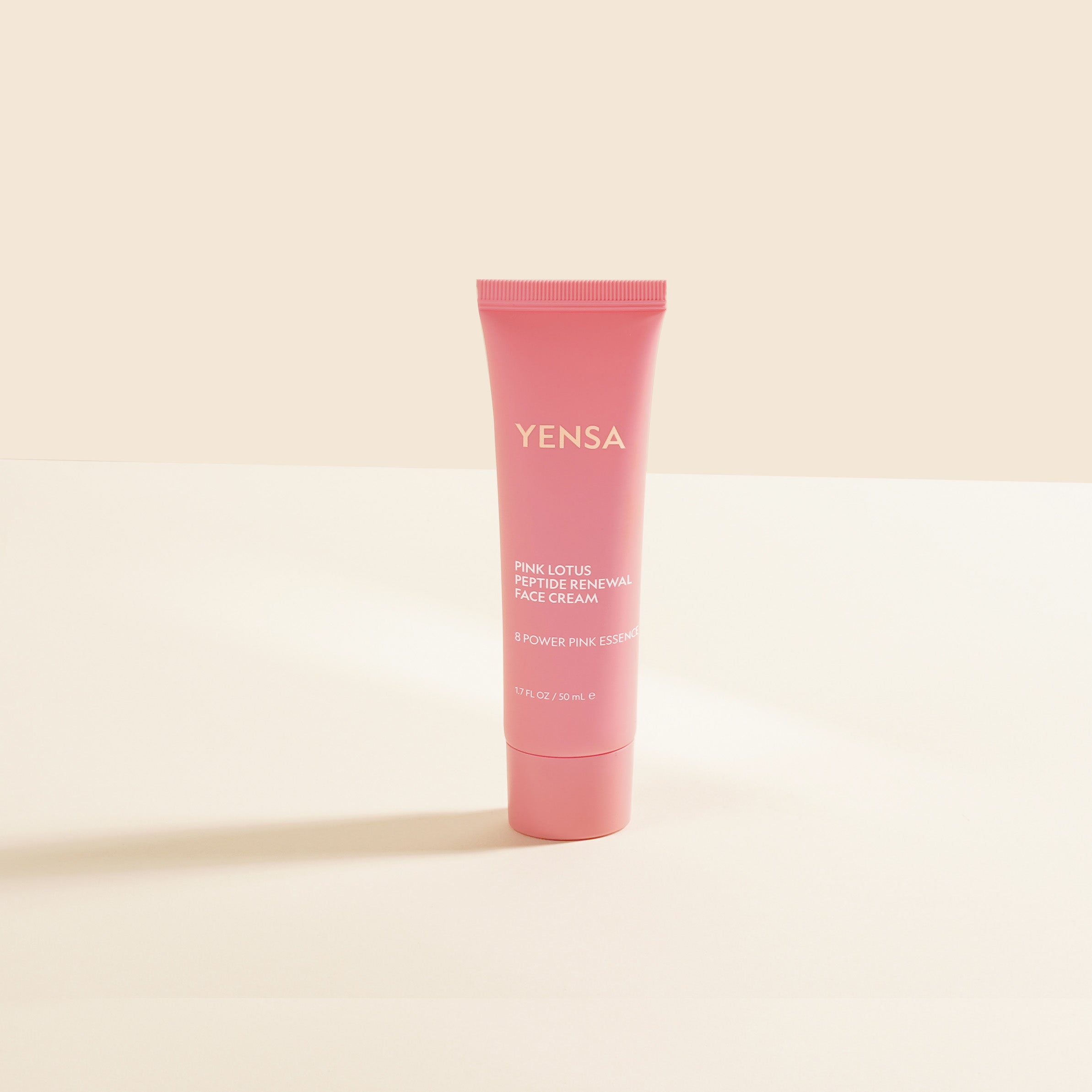 Pink tube of YENSA cream on a beige background