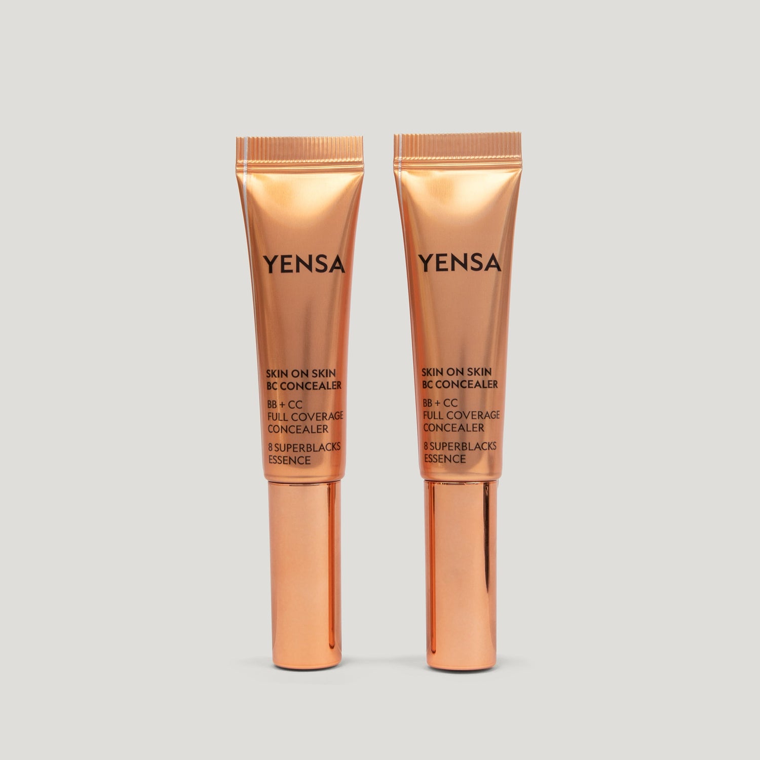 Skin On Skin BB + CC Concealer in two gold tubes displayed on a light background, showcasing full coverage serum formula.