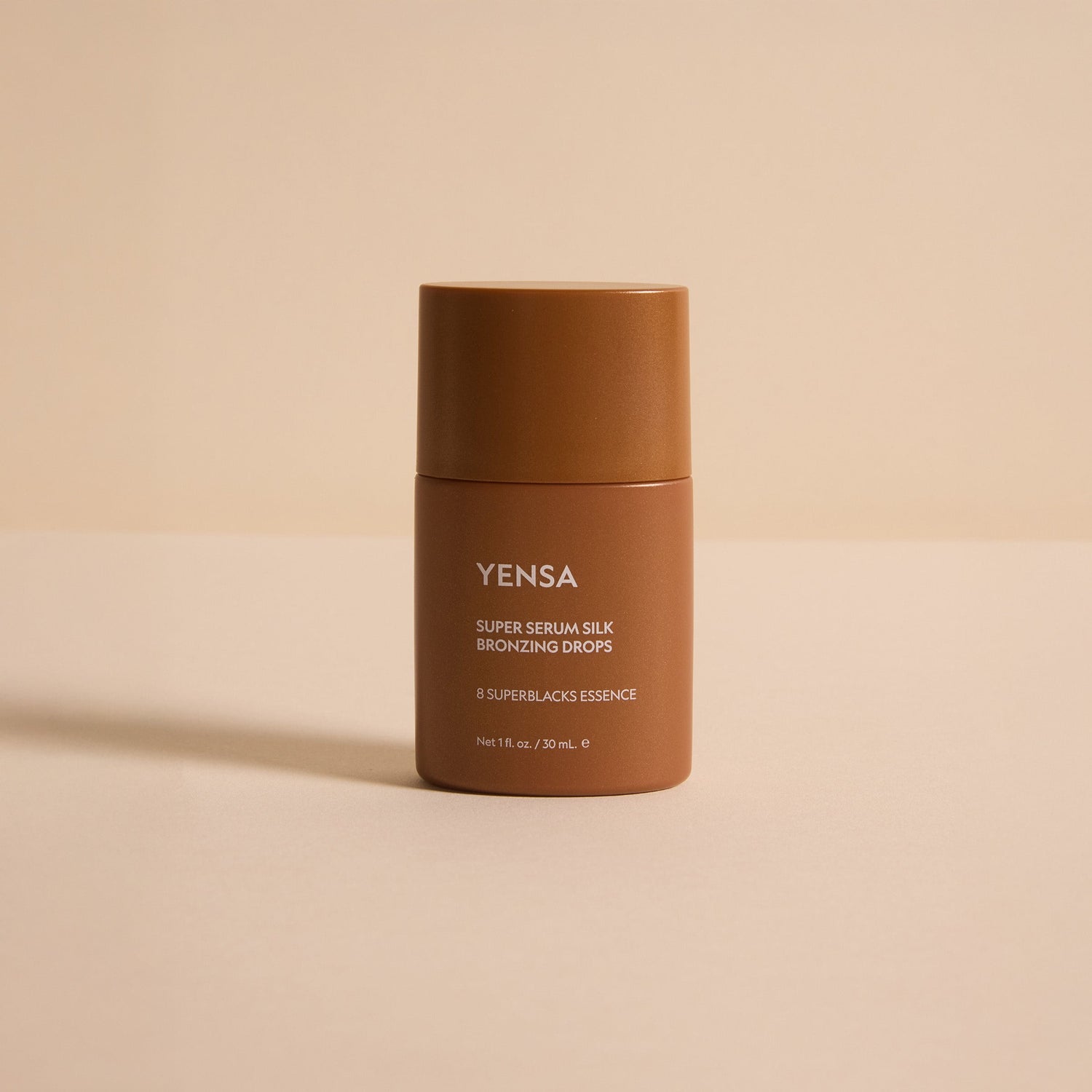 Super Serum Silk Bronzing Drops bottle on a neutral background showcasing its radiant glow properties.