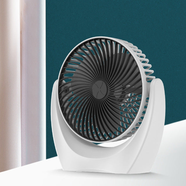 White and black portable fan on a white surface with a teal background